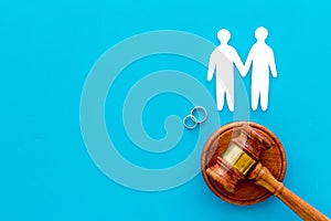 LGBT divorce. Judge gavel, rings, men gay couple on blue background top-down copy space