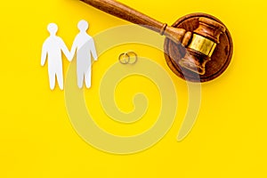 LGBT divorce. Judge gavel, rings, men gay couple on yellow background top-down copy space