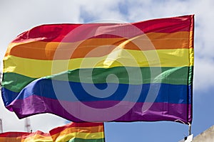 A LGBT gay pride rainbow flag being waved at a pride community celebration event