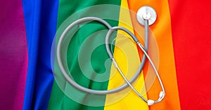 LGBT Health care. Medical Stethoscope on rainbow pride flag background, overhead view