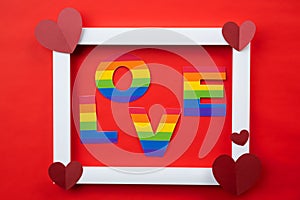 LGBT love paper letters on a frame with hearts against red background