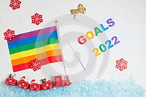 LGBT and New Years goals concept. New Year`s steam locomotive with rainbow flag covered with snow