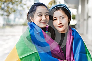 LGBT, portrait of lesbian couple Asian women using lips kissing under rainbow cloth,lesbian concepts.Two pretty women of different