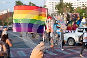 LGBT pride month background. a spectator waves a gay rainbow flag at LGBT gay pride parade festival in Thailand.