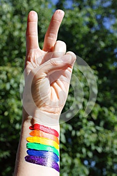 LGBT Pride Month, rainbow flag with victory hand concept.