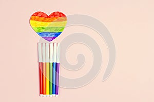 LGBT rainbow ribbon heart with multi-colored markers on a pink background