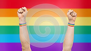 Hands with gay pride rainbow wristbands shows fist photo