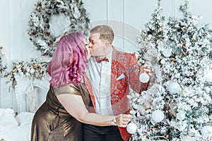 LGBTQ lesbian couple celebrating Christmas or New Year winter holiday together. Gay female lady with butch partner decorating