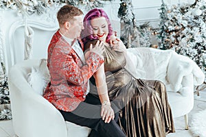 LGBTQ lesbian couple celebrating Christmas or New Year winter holiday together. Gay female lady with butch partner hugging