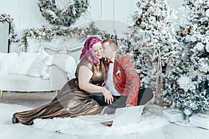 LGBTQ lesbian homosexual couple celebrating Christmas or New Year. Gay young lady female woman with butch partner calling friends