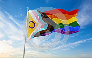 LGBTQ Progress Pride with intersex inclusion flag waving in the wind at cloudy sky. Freedom and love concept. Pride month.