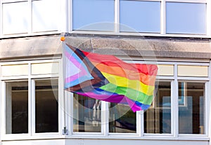 LGBTQ  rainbow flag is flown on the facade of the building. City street. Equal rights. Amsterdam,  Netherlands, Europe