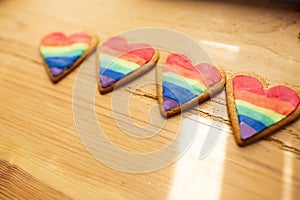 LGTB hearts cookies on a wooden table. Rainbow heart cookie. Heart lgbt+ sign rainbow color stripe. Symbolic free love concept