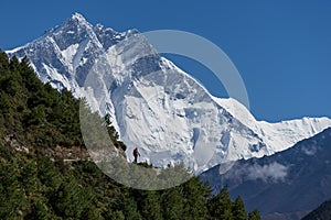 Lhotse mountain peak behind trekker in Everest region, Himalaya