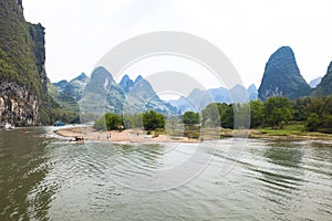 Li River or Li Jiang - Mountains  Island  China. Beautiful sandbank in Li-River with typical peaked karst mountains in background photo