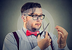 Liar businessman about to cut with scissors his imaginary long nose photo