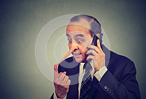 Liar customer service representative. Man with long nose talking on mobile phone lying photo