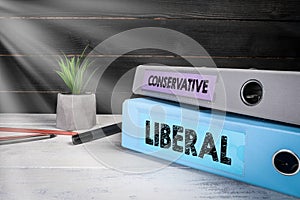 LIBERAL and CONSERVATIVE. Two binders on desk in the office