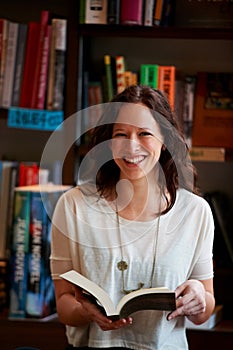 Library, books and portrait of woman in bookstore or shop read for research, learning and relaxing. Literature, customer