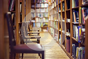 Library with books on shelf and empty chairs