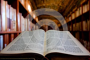 Library filled with books with an ancient book with opened pages