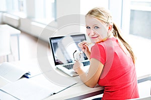 In the library - pretty, female student with books and laptop