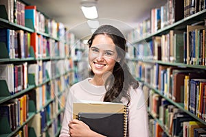 In the library - pretty female student with books working in a h