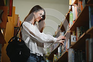 in the library - pretty female student with books working in a high school library.