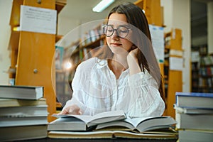 in the library - pretty female student with books working in a high school library.