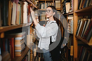 in the library - pretty female student with books working in a high school library.