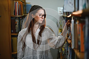 in the library - pretty female student with books working in a high school library.