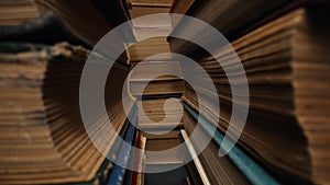 Library stack of old books, slider macro footage in antique shop, bookstore.