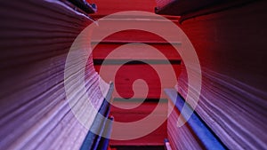 Library stack of old books, slider macro footage in colorful neon shop,bookstore