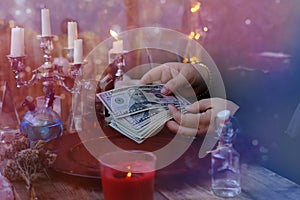 Librate with money, female hands of psychic doing witchcraft passes with dollars, esoteric Oracle performs ritual of removing photo