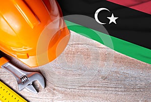 Libya flag with different construction tools on wood background, with copy space for text