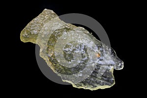 Libyan desert glass, yellow speciman. Translucent to transparent. Smooth, mottled surface. Black background. photo