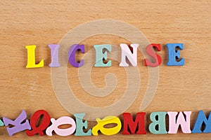 LICENSE word on wooden background composed from colorful abc alphabet block wooden letters, copy space for ad text