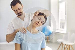 Licensed chiropractor doing neck adjustment to female patient in modern medical office