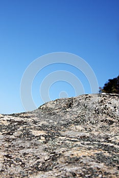Lichen covered rock against blue sky
