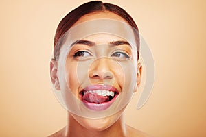 Lick, teeth or happy woman with tongue, smile or thinking of dental wellness against a studio background. Person, mouth