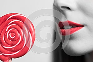 young womans mouth and a red lollipop