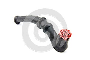 A licorice pipe with red spheres