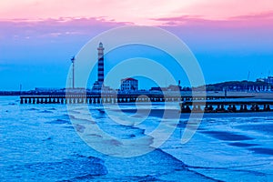 Lido di Jesolo lighthouse and piers on sunrise Adriatic Sea Veneto Italy