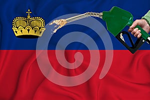 LIECHTENSTEIN flag Close-up shot on waving background texture with Fuel pump nozzle in hand. The concept of design solutions. 3d
