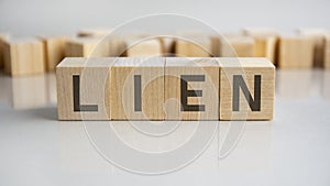 lien text on a wooden blocks, gray background