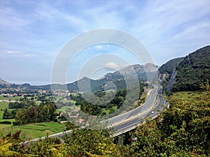 Liendo and highway curve surrounded by mountainous landscape