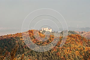 Zrúcanina Lietavského hradu s farebným jesenným lesom na Slovensku