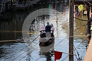 Life along the canal and boatman rowing the Thai traditional small rowboat on the canal
