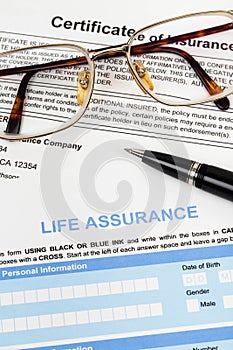 Life assurance application form with pen and glasses