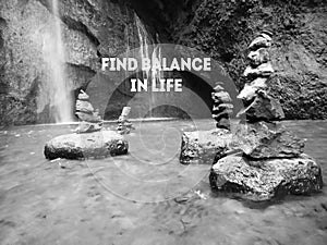 Life balance quote. Inspirational words - Find balance in life. With background of waterfall & stones formations in black and